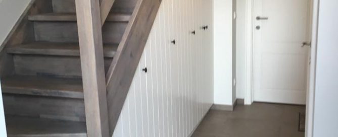 Afwerking van een traphal met ingemaakte kasten. traphal renovatie in Geel, lege ruimte wordt opgevuld door praktische en moderne kasten op maat. Vakmanschap